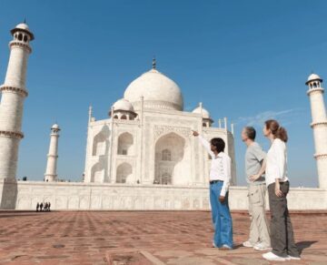 Tourists with a guide at the Taj Mahal in Agra pointing towards the monument