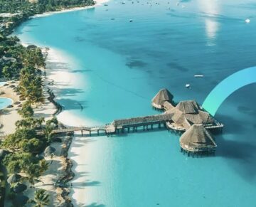 An aerial view of a tropical beach with overwater bungalows